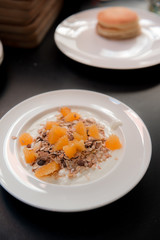 homemade muesli with orange on white dish