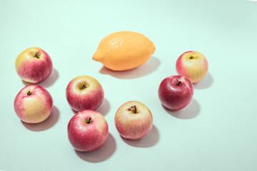 fresh apples and lemon on light blue background