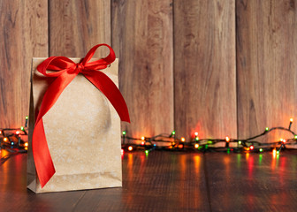 Gift bag made of handmade kraft paper on a wooden background in a Christmas style, decorated with...