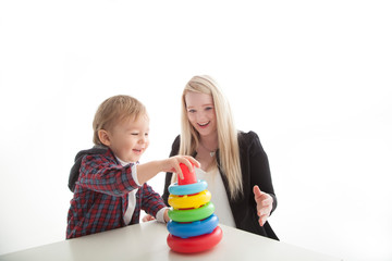 mother and son playing with ring stacking toy on white background