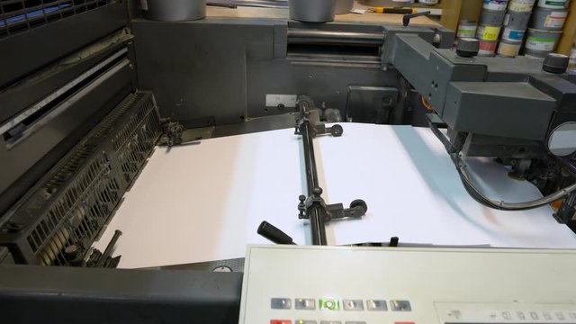 Printed sheets of paper are served in the printing press