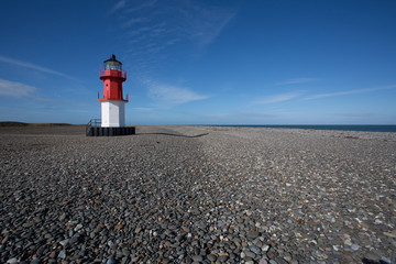 Fototapeta na wymiar Lighthouse on pebble beach, Point of Ayre, Isle of Man, British Isles