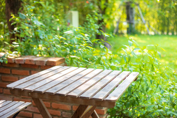 Selective focus of empty wooden table or plank with chair or bench on background for product...