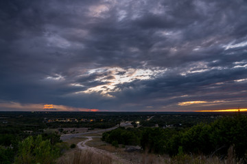 Aerial View of Highway CRossing the Texas Hill Country with Large Storm in the Sky