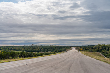 Wide Angle View of Two Lane Highway Running into the Distance in the Hill Country Side