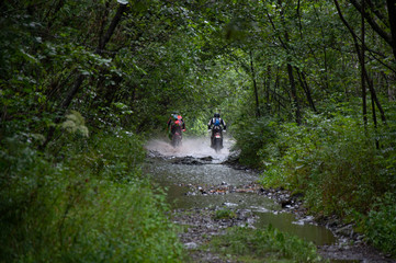 Obraz premium Travelling on an enduro motorcycle in the taiga.