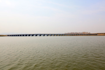 Obraz premium The arch bridge is in the water of the lake and is seen in the distance.