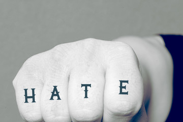 Eine Faust mit dem Tattoo Hass