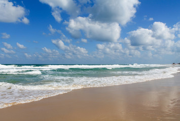 Sea foam on the sandy beach at Bat Yam, Israel. Waves on the blue stormy sea. Mediterranean coastline. Travelling picture. Turquoise water and sandy beach