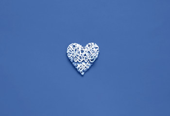 Valentines Day concept. Creative paper background with wicker heart. Blue trendy color.Holiday concept for postcard or invitation. Top view, copy space