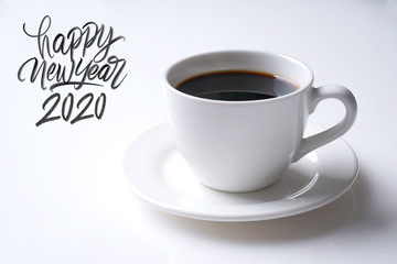 Cup of black coffee and happy new year 2020 great hand latter on white