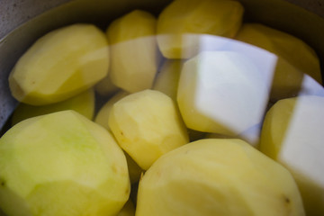 Peeled potatoes in a pan with water. copy space, top view, flat lay, background with blank space for text