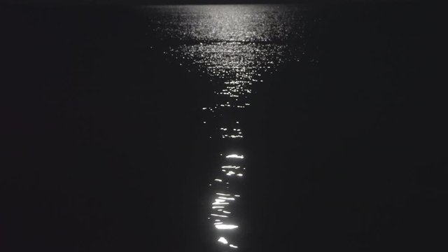 Still shot of a calm sea lit by a moonlight