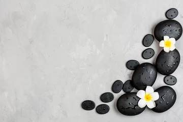 Poster Bovenaanzicht van hot spa-stenen voor massagebehandeling op grijze betonnen achtergrond met kopieerruimte. Elegante en luxe spa. Plat leggen, overhead, mock-up, sjabloon. Gezondheids- en schoonheidsverzorgingsconcept © Алина Бузунова