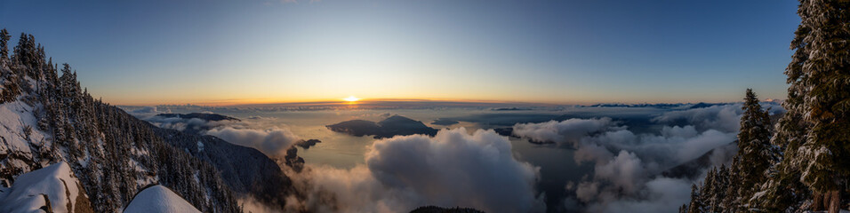 St Mark's Summit, in Howe Sound, North of Vancouver, British Columbia, Canada. Panoramic Canadian Mountain Landscape View from the Peak during cloudy winter sunset.