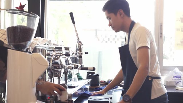 young asian  barista man serving customers in cafe .Successful small business owner standing with crossed arms .Happy male business owner standing in front of counter cafe .