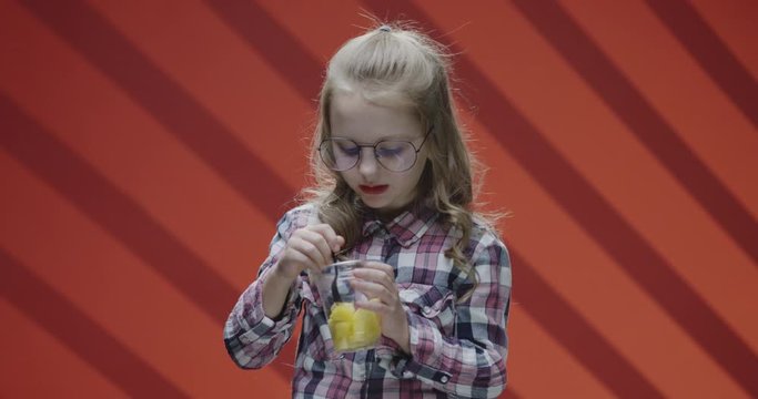 Girl eating pineapple from plastic cup