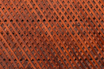 Naklejka premium Brown wooden wall lattice background texture. wooden fence cross pattern. Crossing a tree with nails.