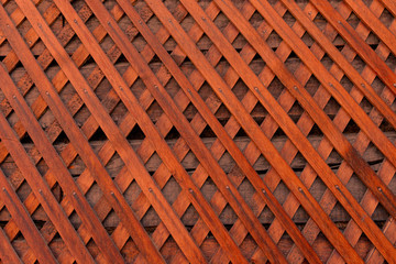 Brown wooden wall lattice background texture.  wooden fence cross pattern. Crossing a tree with...