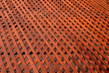 Brown wooden wall lattice background texture.  wooden fence cross pattern. Crossing a tree with nails.