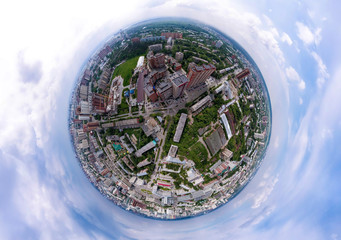Aerial view of the city with traffic, streets and buildings with green trees and rails under the...