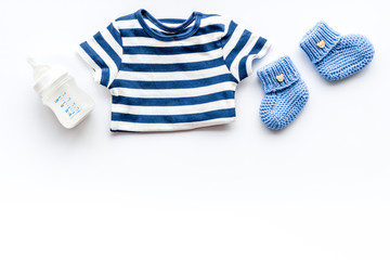 Baby background - blue color. Clothes and accessories for newborn boy on white table top-down frame copy space