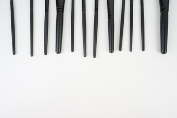 A set of a black make up brushes over the white background