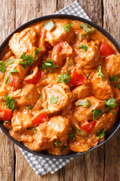 West African chicken mafe in peanut sauce close-up in a plate. Vertical top view
