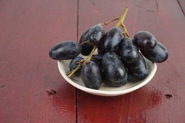 Fresh grape fruits plated over the wooden background