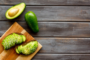 Healthy breakfast. Avocado toast on dark wooden background top view copy space