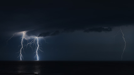 Naklejka na ściany i meble Extreme Weather With Lightning At Night Over The Baltic Sea Outside City Of Visby At island Of Gotland, Sweden