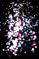 Black background with bright multicolor bokeh lights. Holiday, Christmas and New Year background. Ideal to layer with any design. Vertical