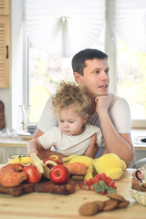 Time for vitamins. Cute little girl and her handsome dad having breakfast at the kitchen table .