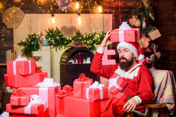 Obraz na płótnie Canvas Sending gifts. Greetings from Santa. Santa claus residence. Winter holidays. Cozy home atmosphere. Bearded man sit in armchair with pile of gifts. Parcels gifts will be delivered to its destination