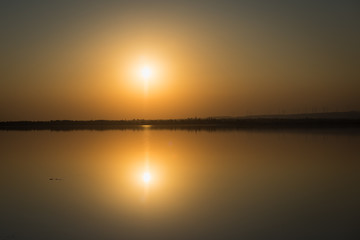 Fototapeta na wymiar Sunset, setting sun, water reflection over Salt Lake in Larnaca, Cyprus