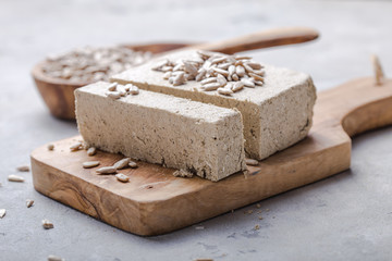 Sunflower halva with seeds  on wooden background. Festive Oriental delicacy