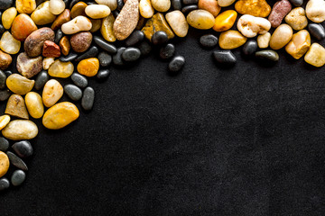 Sea stones background with black copy space top-down frame