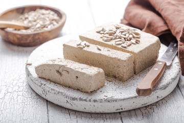 Sunflower halva with seeds  on wooden background. Festive Oriental delicacy
