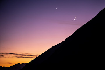 A perfect shot taken while the sun was setting and the moon was lightening up the sky.  The Perfect mixture of fading and emerging colors that can lure anyone to a different reality.