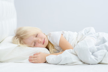 Obraz na płótnie Canvas little girl sleeping on her bed