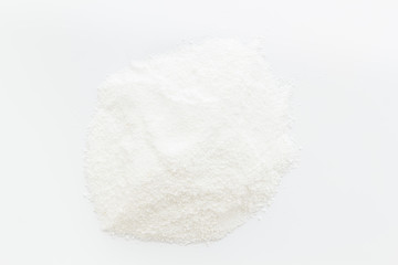 Washing powder scattered on white background top view