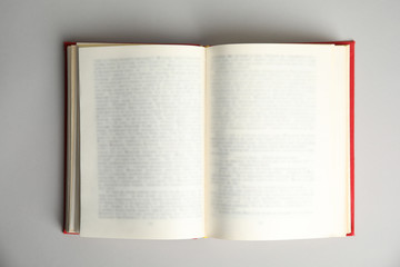 Open book on light grey background, top view. Space for text