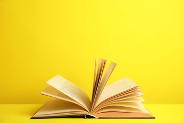 Open old hardcover book on yellow background. Space for text