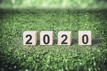 New year 2020 on wooden cubes with green background.