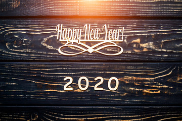 Happy new year 2020 on wooden brown background.