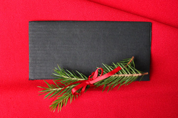 Greeting card, postcard happy new year. Black card on a red background with spruce branches and a red ribbon.