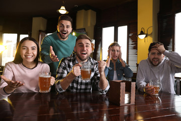 Group of friends watching football in sport bar
