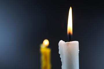 burn white and yellow candle in the dark background