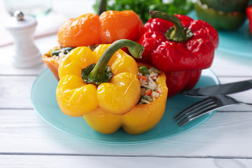 Tasty stuffed bell peppers on white wooden table