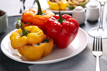 Tasty stuffed bell peppers served on grey table